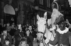 127183 Afbeelding van het onthaal van Sinterklaas en Zwarte Piet op de Stadhuisbrug te Utrecht, met links (met hoed) ...